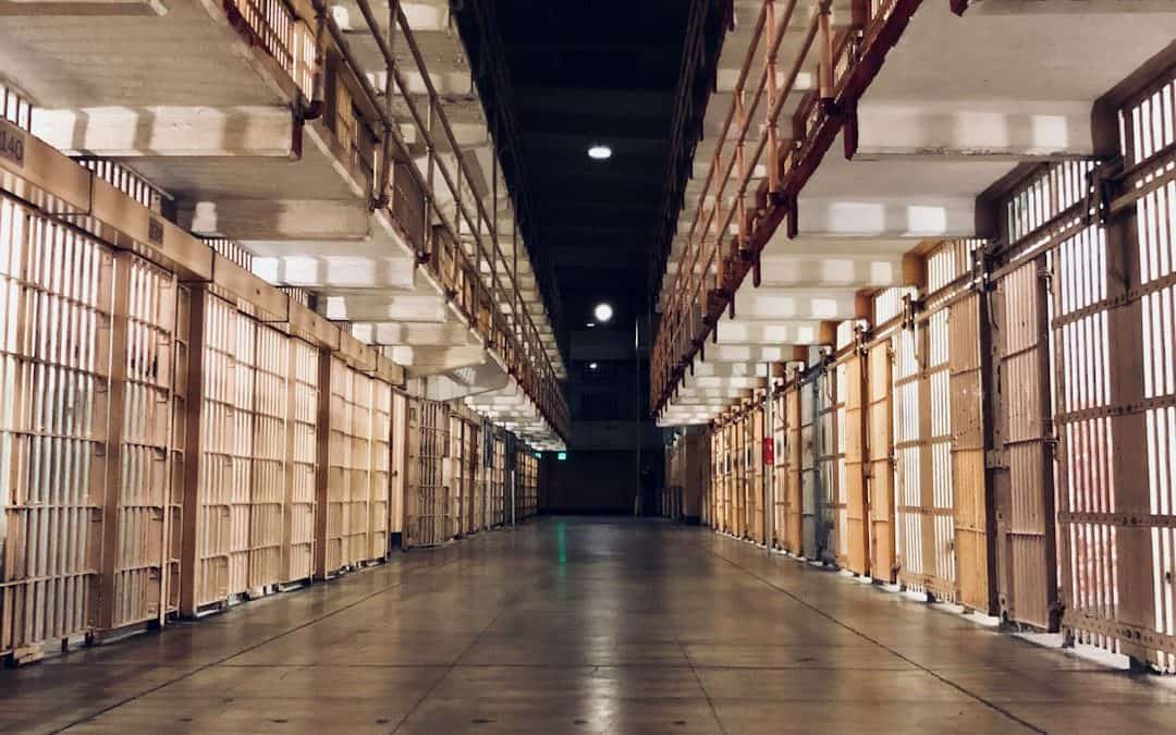 Photo of the inside of a prison area containing many cells.